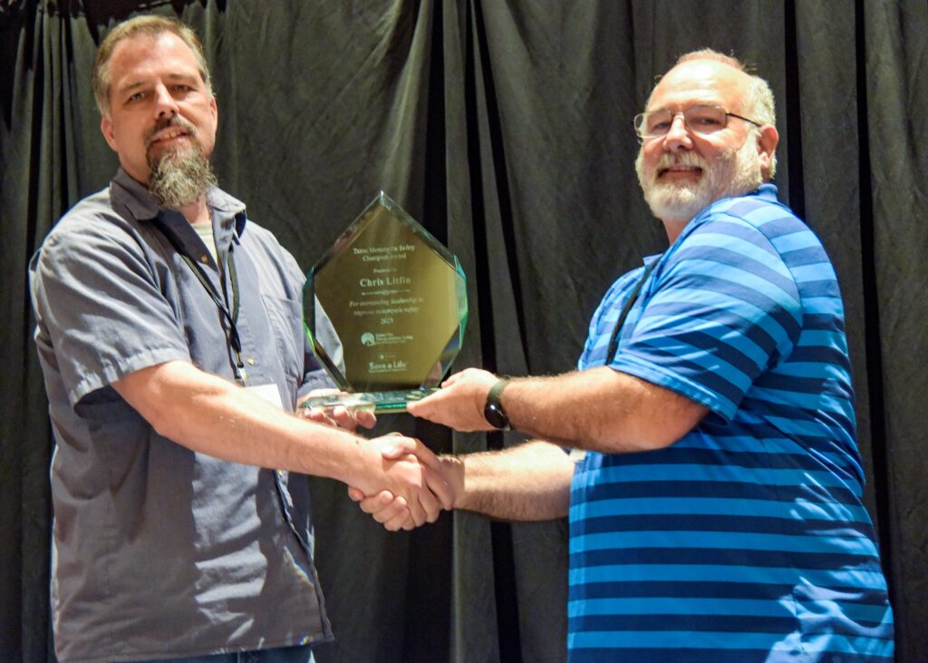 Award recipient Chris Litfin (left) shaking hands and posing with his award with TMSC Chair Maurice Maness (right).