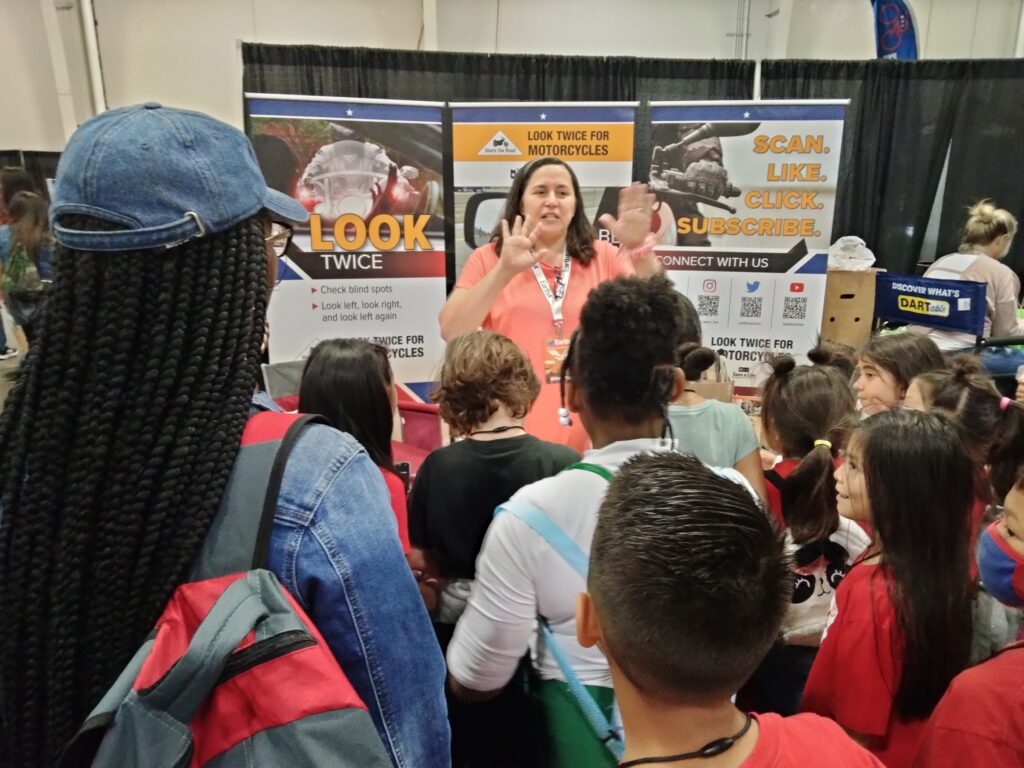 Kim S. teaches students about motorcycle safety during "school day" at EarthX.