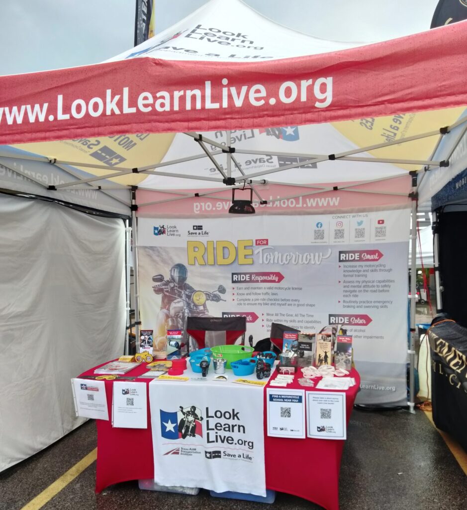 Look Learn Live booth at the 2024 Lone star Rally with materials on the table.